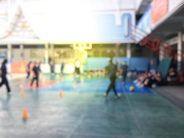blurred image of children or male and female students in secondary school are learning football or soccer on school playground in physical education time. bangkok,thailand. physical activities concept - secondary action imagens e fotografias de stock