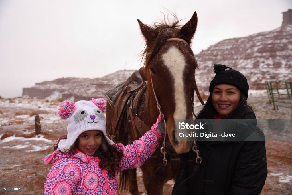 Preparing for horse riding in Utah Mother and daughter in winter preparing for a ride in the snow. Navajo Culture Stock Photo
