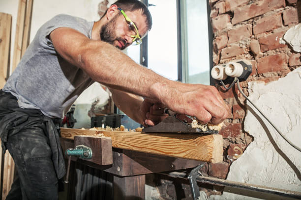 istock Carpenter treating a wooden bar with a black jack plane 915534110