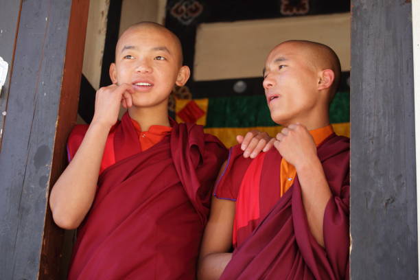 Two young Monks chatting and enjoying the festive atmosphere in Bhutan. stock photo