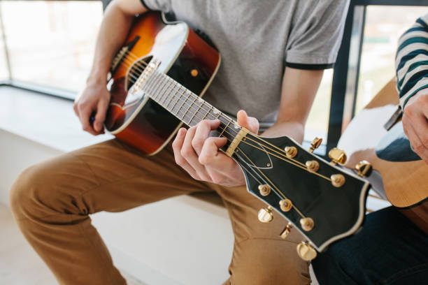 istock Learning to play the guitar. Extra-curricular lessons for adults. Music education. Masterclass playing the guitar 915541442