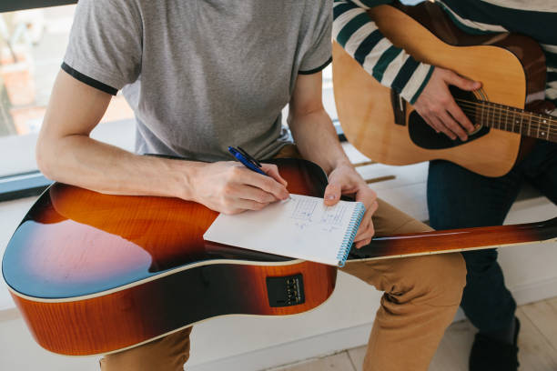 istock Learning to play the guitar. Extra-curricular lessons for adults. Music education. Masterclass playing the guitar 915543786
