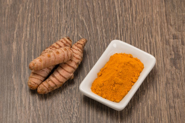 istock turmeric powder with turmeric root over wood 915544030