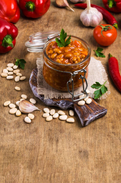 Canned beans with vegetables Canned beans with vegetables in tomato sauce on wooden background. Selective focus. halle north rhine westphalia stock pictures, royalty-free photos & images