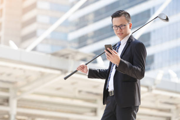 Business man holding smartphone and playing golf stock photo