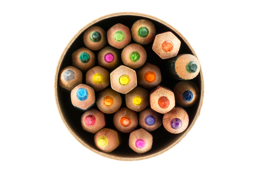Top view of colorful wood pencils in a circle box isolated on white background.