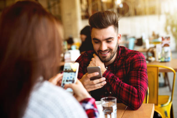 istock Couple in coffee shop using their phones. 915560250