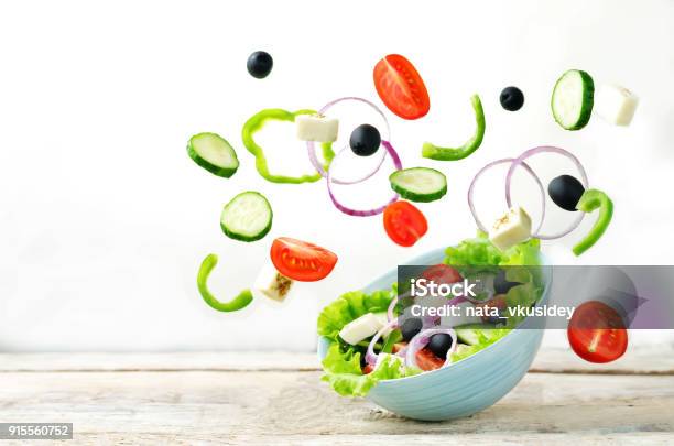 Greek Salad With Flying Ingredients To Prepare It Stock Photo - Download Image Now - Salad, Cucumber, Flying