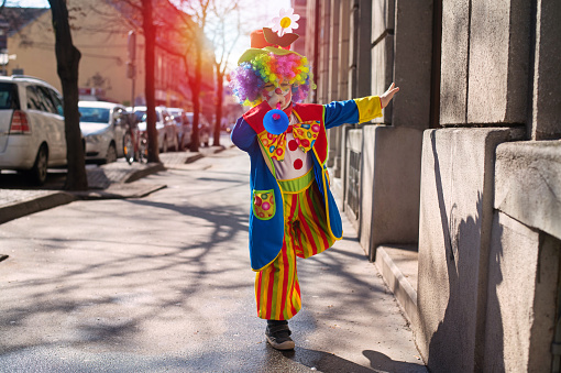 Little boy dressed as a clown.