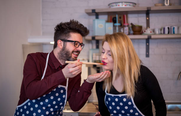 istock Attractive couple is cooking on kitchen. Looking on each other and smiling. 915571072