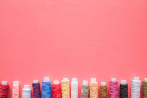 パステル ピンクの背景上のスレッドのカラフルなスプール。洋裁のために模擬やテキスタイル ショップ広告として提供または他のアイデア。女らしい趣味。縫製概念。テキストまたはロゴ� - womanly ストックフォトと画像