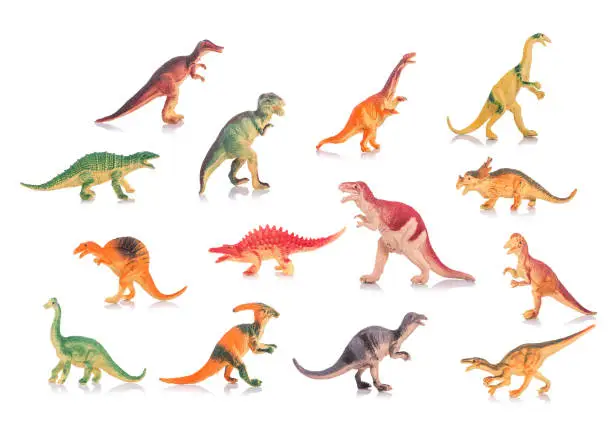 Photo of Collection of silicone or plastic toy dinosaurs. Studio shot and on white