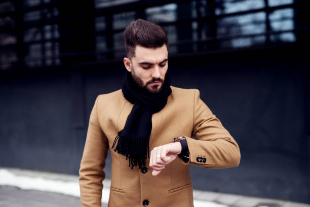 istock Young modernly dressed man looking at his watch. Waiting for his date to come. 915577762