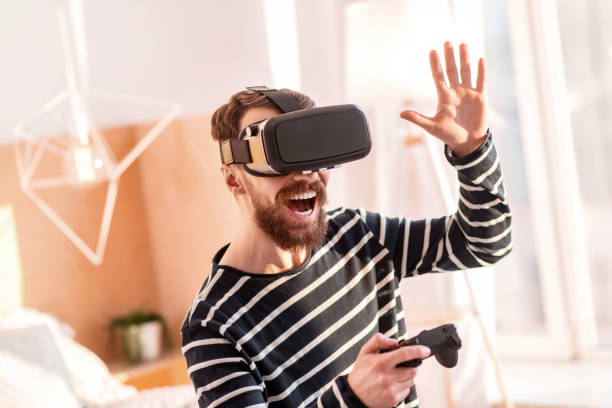 istock Cheerful gay man playing VR game 915586062