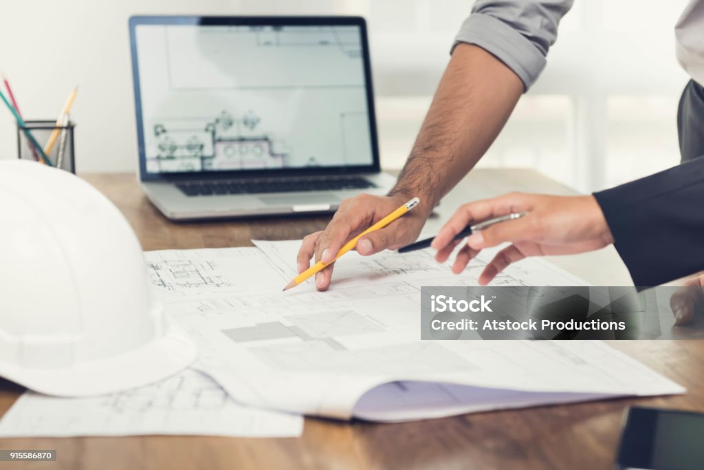 Architetti che discutono di un progetto in ufficio - Foto stock royalty-free di Progettare