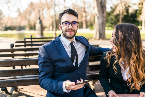 istock Happy business people having a break in the park 915589682