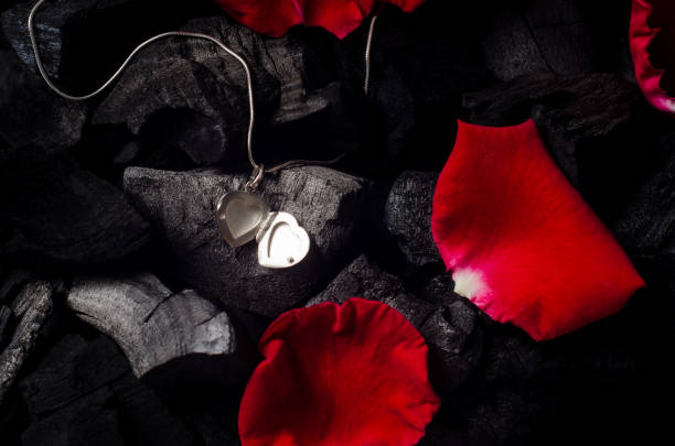 Silver heart  shape locket with necklace on black charcoal texture background