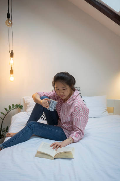 istock Young Chinese woman reading book 915595052