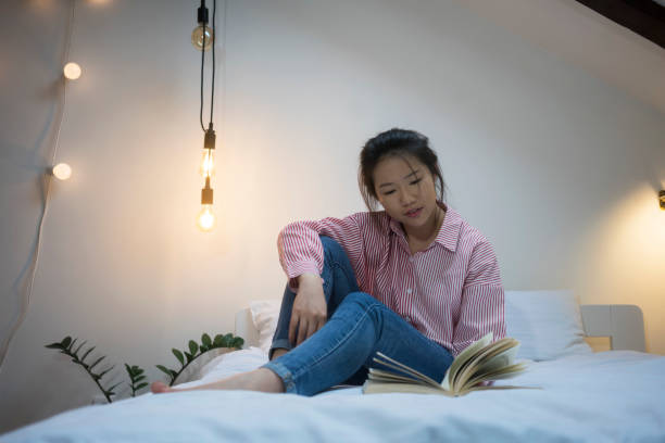 istock Young Chinese woman reading book 915597120