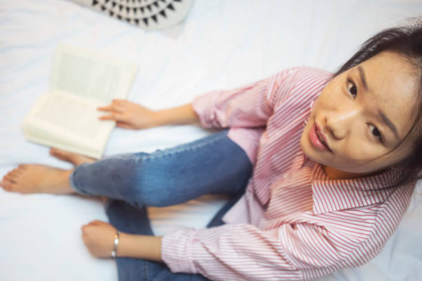 istock Young Chinese woman reading book 915597346