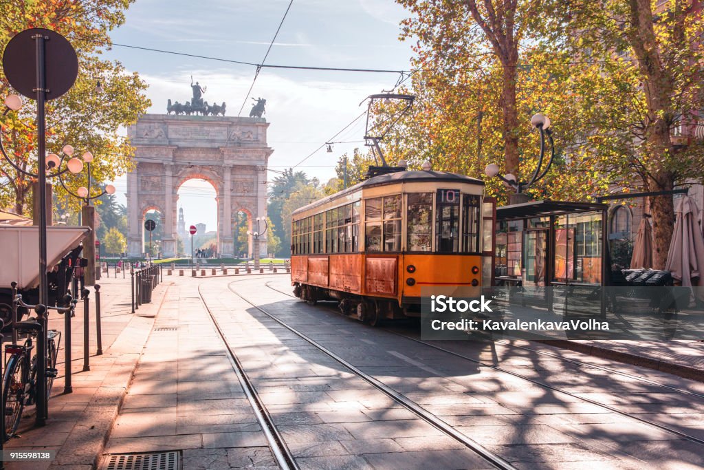 Famous vintage tram in Milan, Lombardia, Italy Famous vintage tram in the centre of the Old Town of Milan in the sunny day, Lombardia, Italy. Arch of Peace, or Arco della Pace on the background. Milan Stock Photo