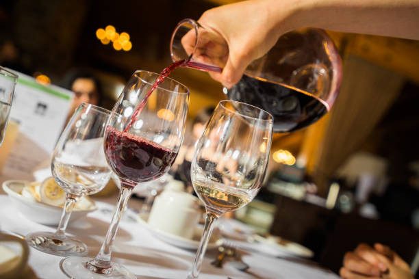 рука заливки красного вина в стакан - wine decanter elegance pouring стоковые фото и изображения