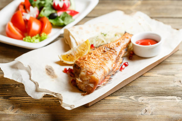 sea bass grill. Serving on a wooden Board on a rustic table. Barbecue restaurant menu, a series of photos of different meats