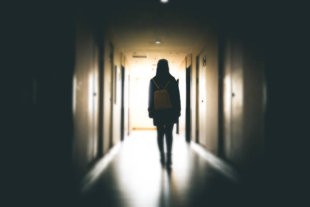 Young woman in dark building walkway stock photo