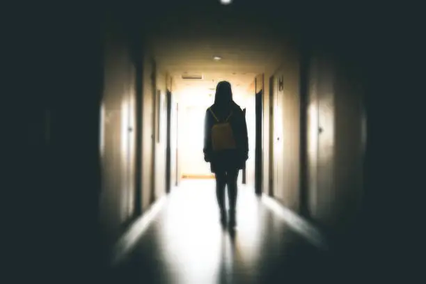 Photo of Young woman in dark building walkway