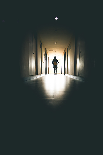 Young woman in dark building walkway