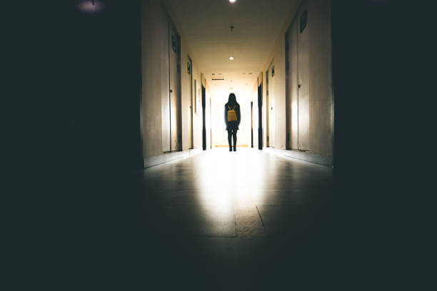 istock Young woman in dark building walkway 915612996