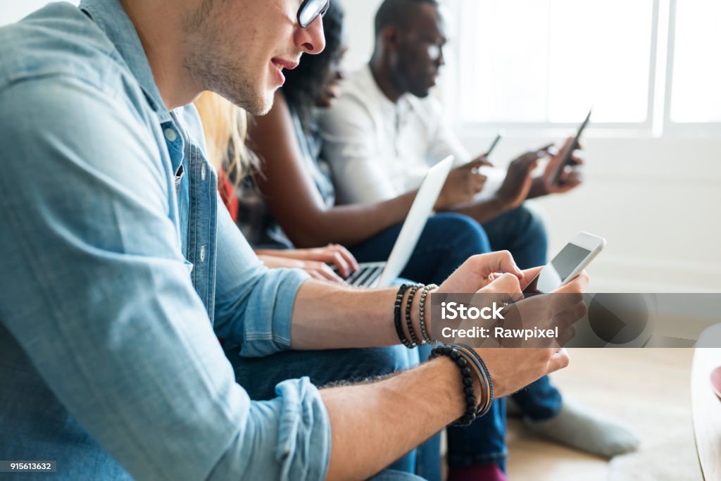 Gruppe von diversen Freunden rumhängen und Verwendung von digitalen Geräten - Lizenzfrei Ausrüstung und Geräte Stock-Foto