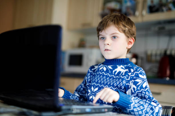 istock kid boy with glasses making preschool homework on computer 915617136