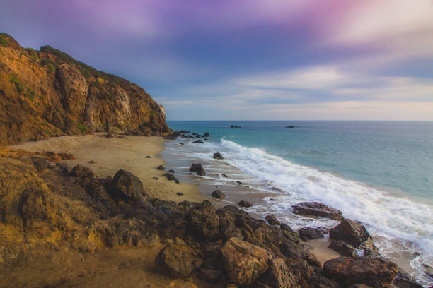 Secluded Pirate'sCove Beach at Sunset Secluded Pirate's Cove Beach at sunset with a colorful sky and ocean water flowing around rock formations, Point Dume, Malibu, California pirate's cove stock pictures, royalty-free photos & images