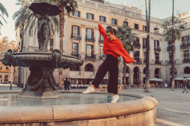 Girl standing on tip toes at the fountain Smiling woman trying to keep balance while walking on one leg at the fountain tiptoe stock pictures, royalty-free photos & images