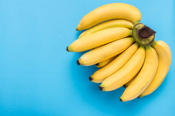 istock Yellow ripe banana on blue background with space for text or design 915621140