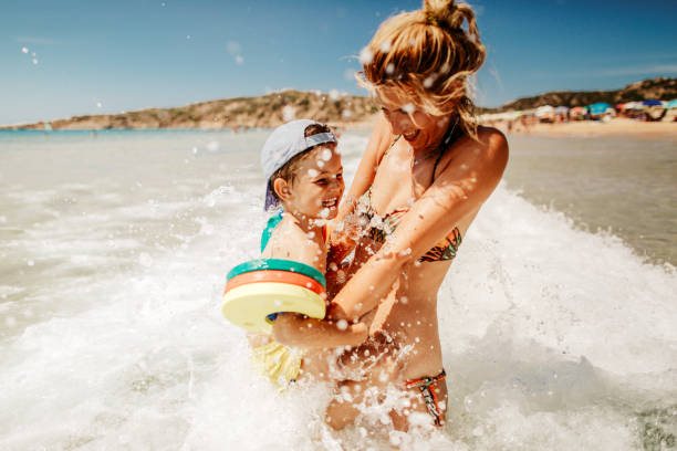 Enjoying sea water Photo is showing young mother with her son, enjoying bathing in a sea water children at the beach stock pictures, royalty-free photos & images