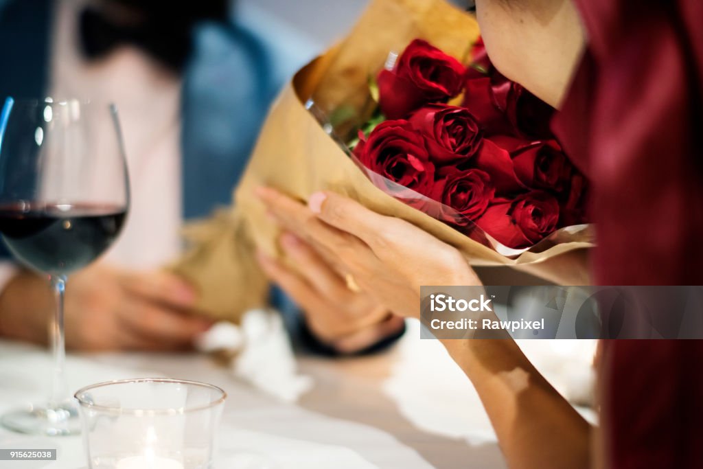 Homme donnant un bouquet rose rouge - Photo de Saint Valentin libre de droits