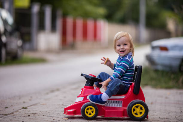 istock Cute boy relaxing on toy car and having a snack. 915626388