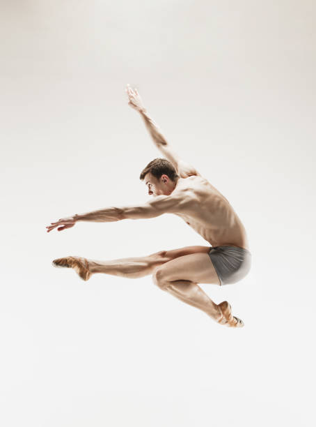 istock Athletic ballet dancer in a perfect shape performing over the grey background 915628778