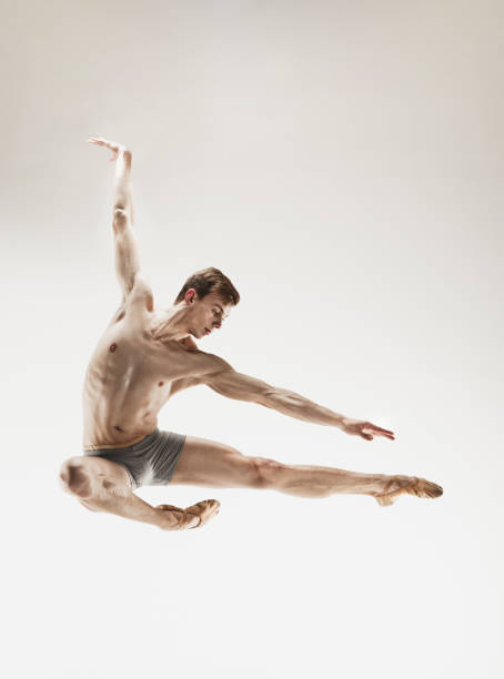 istock Athletic ballet dancer in a perfect shape performing over the grey background 915628886