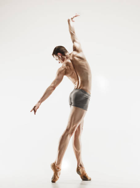 istock Athletic ballet dancer in a perfect shape performing over the grey background 915628920