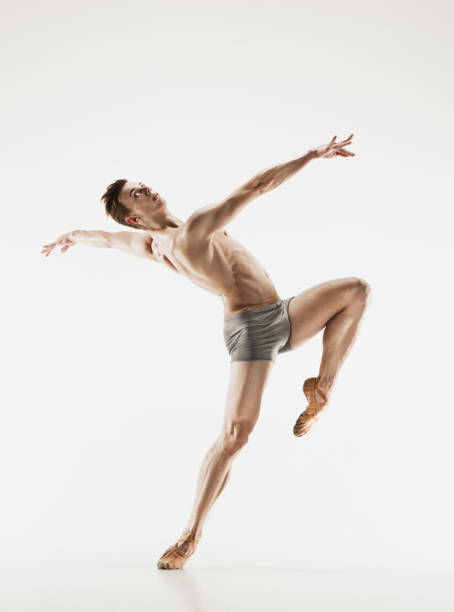 istock Athletic ballet dancer in a perfect shape performing over the grey background 915629044