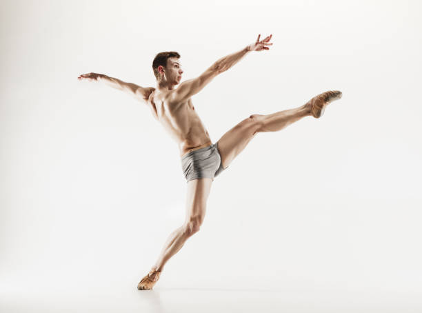 istock Athletic ballet dancer in a perfect shape performing over the grey background 915629072