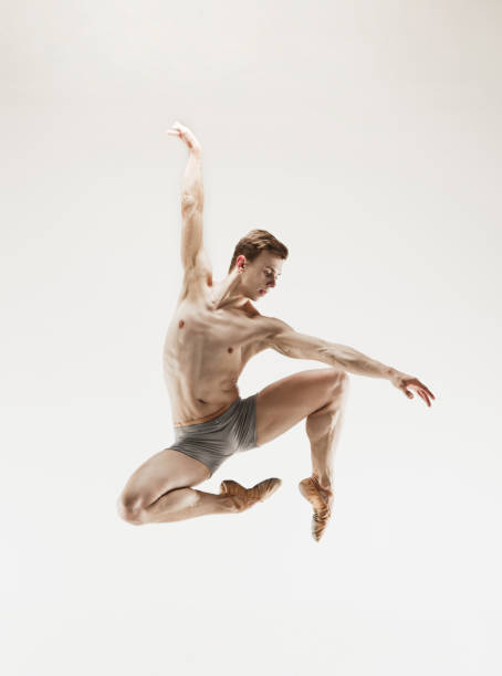 istock Athletic ballet dancer in a perfect shape performing over the grey background 915629096