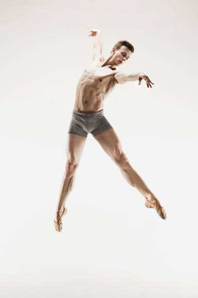 istock Athletic ballet dancer in a perfect shape performing over the grey background 915629130