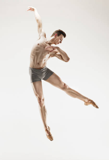 istock Athletic ballet dancer in a perfect shape performing over the grey background 915629154