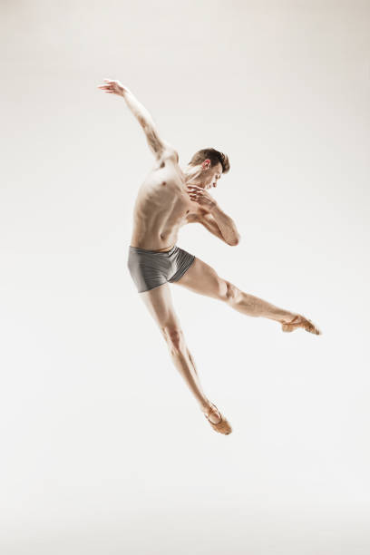 istock Athletic ballet dancer in a perfect shape performing over the grey background 915629232