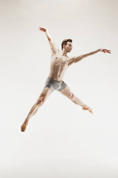 istock Athletic ballet dancer in a perfect shape performing over the grey background 915629282
