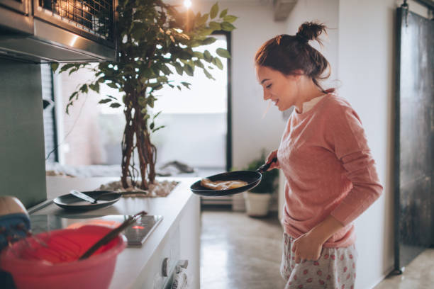 istock Young woman making pancakes 915629668